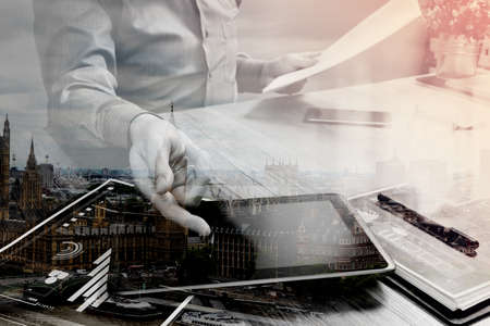 Double exposure of businessman working with digital tablet computer and smart phone and laptop computer with financial business strategy layer effect,London architecture buldingsの写真素材