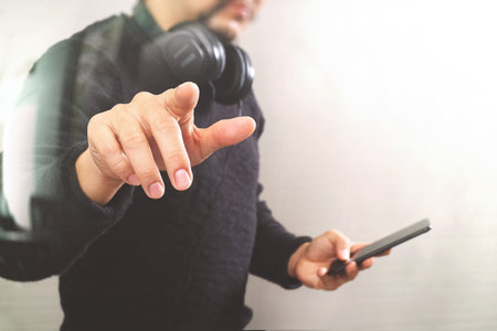 Businessman hand pressing an imaginary button,holding smart phone,digital screen graphic virtual...