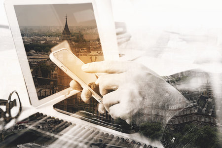 Double exposure of two colleague web designer discussing data and digital tablet and computer laptop...