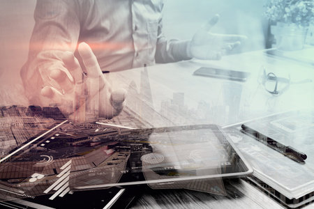 Double exposure of businessman working with digital tablet computer and smart phone and laptop...