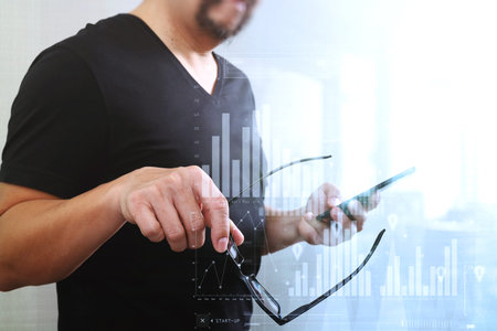 Designer hand holding eyeglasses,using smart phone,virtual computer interface omni chanel business screenの写真素材