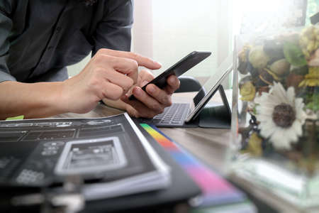 businessman hand using mobile payments online shopping,omni channel,laptop computer on wooden desk,glass vase flowersの写真素材