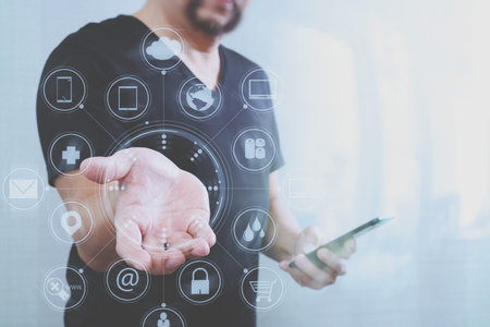 Designer hand pressing an imaginary button,holding smart phone,virtual digital screen graphic icons,channel,diagram interface computer,filter effectの写真素材