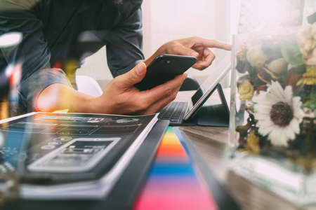 businessman hand using mobile payments online shopping,omni channel,laptop computer on wooden desk,glass vase flowers,filterの写真素材