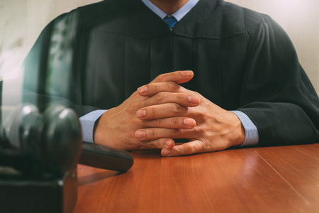 justice and law concept.Male judge in a courtroom striking the gavel,working with digital tablet...