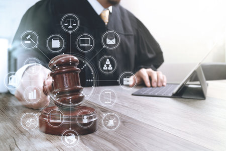 Hands of businessman using mobile phone in modern office with laptop and digital tablet computer...