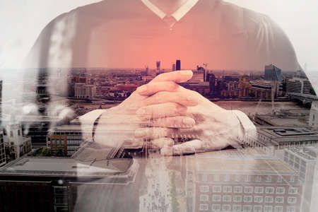 double exposure of justice and law concept.Male judge in a courtroom with the gavel,working with digital tablet computer on wood table,London architecture cityの写真素材