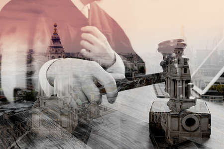 double exposure of justice and law concept.Male judge in a courtroom striking the gavel,working with digital tablet computer docking keyboard on wood table,London architecture cityの写真素材