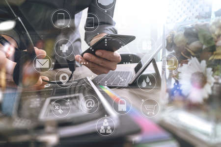 Man using VOIP headset with digital tablet computer docking keyboard,smart phone,concept communication, it support, call center and customer service help desk,vase flowers on wooden table,business strategy icons interface virtual screenの写真素材