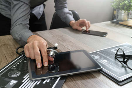 Doctor working with digital tablet computer with smart phone in medical workspace office and video conference as conceptの写真素材