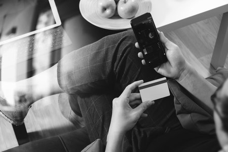 hipster hand using smart phone and laptop compter,holding cradit card payments online...