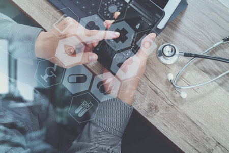 top view of medical doctor hand working with smart phone,digital tablet computer,stethoscope...