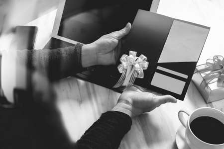 Businessperson Hands holding New Gift Card or Credit card,digital tablet computer dock keyboard,smart phone on marble desk,black whiteの写真素材