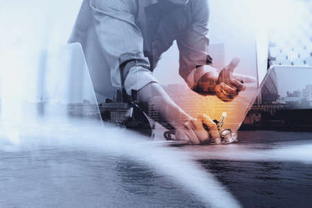 Double exposure of smart medical doctor hand working with smart phone,digital tablet computer,stethoscope eyeglass,London architecture bulidingsの写真素材