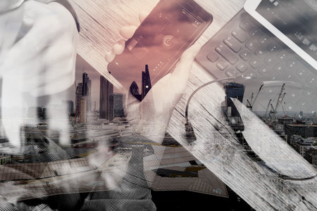 double exposure of man hand using VOIP headset with digital tablet computer docking keyboard,smart phone,concept communication, it support, call center and customer service help desk,London architecture cityの写真素材