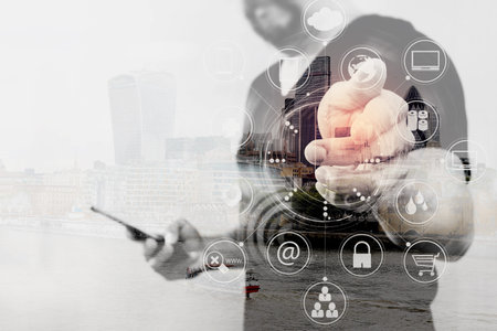 Double exposure of Designer hand pressing an imaginary button,holding smart phone,digital screen...