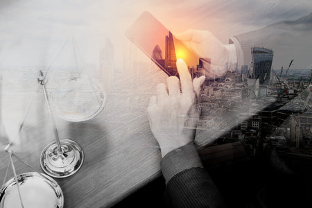 double exposure of justice and law concept.Male lawyer in office with the gavel,working with smart...