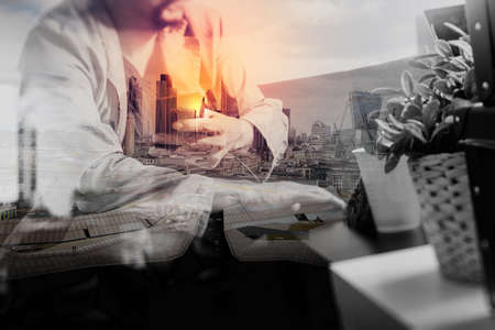 double exposure,hipster hand using smart phone,digital tablet docking keyboard,coffee cup, payments online business,sitting on sofa in living room,work at home concept,London architecture cityの写真素材