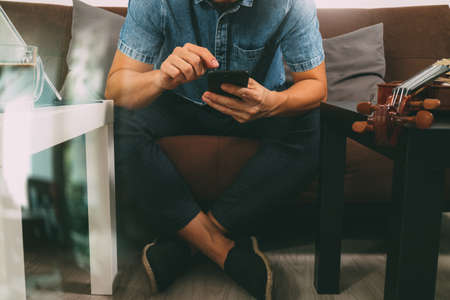 hipster hand using smart phone,digital tablet docking keyboard,holding cradit card payments online business,sitting on sofa in living room,work at home concept,filter effectの写真素材