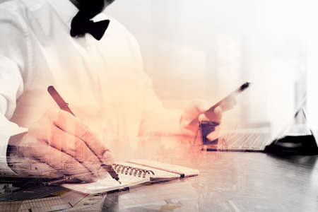 Double exposure of Justice and Law context.Male lawyer hand working with smart phone,digital tablet computer docking keyboard with gavel and document on wood table,London architecture cityの写真素材