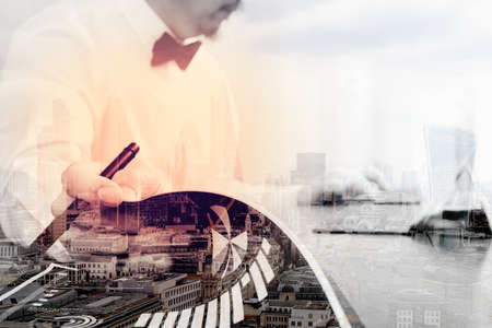 Double exposure of Justice and Law context.Male lawyer hand working with smart phone,digital tablet computer docking keyboard with gavel and document on wood table,London architecture cityの写真素材