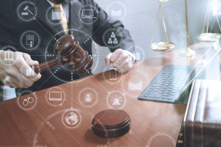 justice and law concept.Male judge in a courtroom with the gavel,working with smart phone,digital...