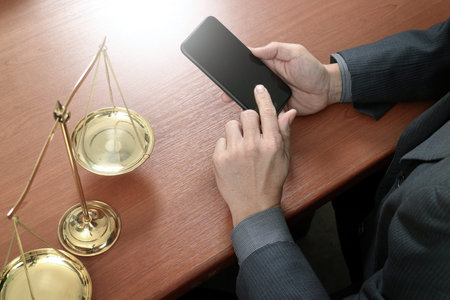 justice and law concept.Male lawyer in office with the gavel,working with smart phone,digital tablet...