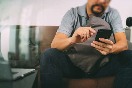 hipster hand using digital tablet docking keyboard and smart phone for mobile payments online business,omni channel,sitting on sofa in living room,filter effectの写真素材