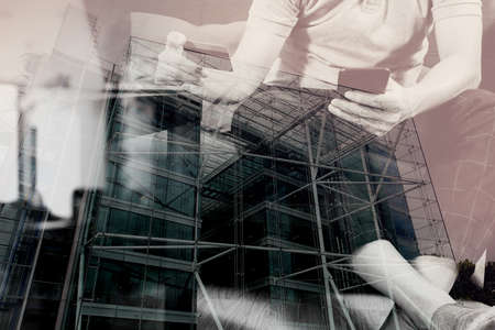 double exposure of hipster hand using smart phone,digital tablet docking keyboard,holding cradit card payments online business,sitting on sofa in living room,work at home concept,London architecture cityの写真素材