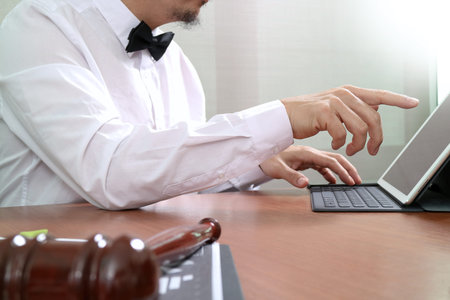 Hands of businessman using mobile phone in modern office with laptop and digital tablet computer...