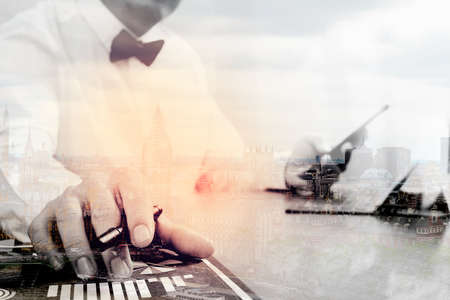 Double exposure of Justice and Law context.Male lawyer hand working with smart phone,digital tablet computer docking keyboard with gavel and document on wood table,London architecture cityの写真素材