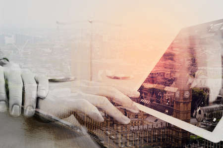 justice and law concept.Male lawyer in office with the balance brass scale,hand working with smart phone and digital tablet computer on wooden desk with london city background,double exposureの写真素材