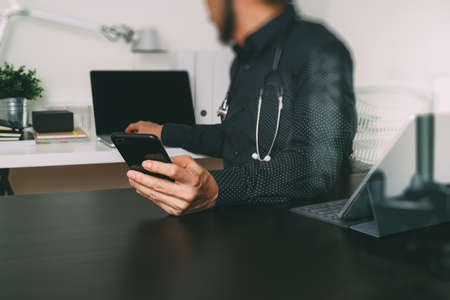 Medical technology concept. Doctor hand working with smart phone,laptop,modern digital tablet dock screen computer in modern clinic office room,filter effectの写真素材