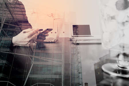 businessman or Designer using smart phone with latop and digital tablet computer in modern office with London city background,double exposureの写真素材