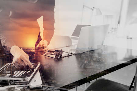 businessman or Designer using smart phone with latop and digital tablet computer and document on desk in modern office with London city background,double exposureの写真素材