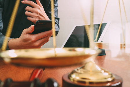 justice and law concept.Male lawyer in office with the gavel,working with smart phone and digital...