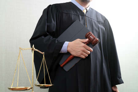 justice and law concept.Male judge in a courtroom with the gavel and balance scale and digital tablet computerの写真素材