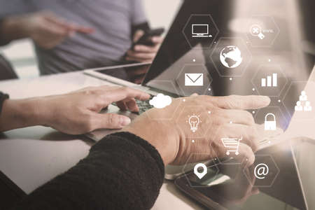 co working team meeting concept,businessman using smart phone and laptop and digital tablet computer in modern office with virtual interface icons network diagramの写真素材