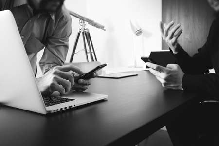 co working team meeting concept,businessman using smart phone and digital tablet and laptop computer in modern office,black and whiteの写真素材