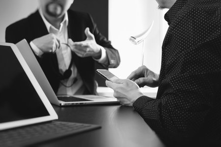co working team meeting concept,businessman using smart phone and digital tablet and laptop computer in modern office,black and whiteの写真素材