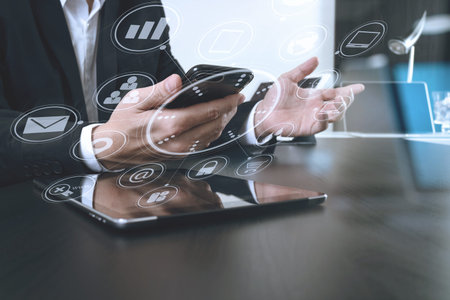businessman working with smart phone and digital tablet and laptop computer in modern office with...