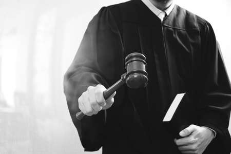 justice and law concept.Male judge in a courtroom with the gavel and holy book,black and whiteの写真素材