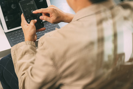 hand using smart phone and digital tablet computer for online banking payment communication in modern officeの写真素材