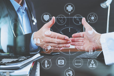 Medical and health care concept,Doctor and patient shaking hands in modern office at hospital with...