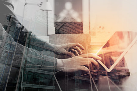 Double exposure of businessman or Designer using digital tablet computer on black desk in modern...