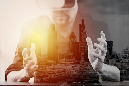 businessman wearing virtual reality goggles in modern office with mobile phone using with VR headset...
