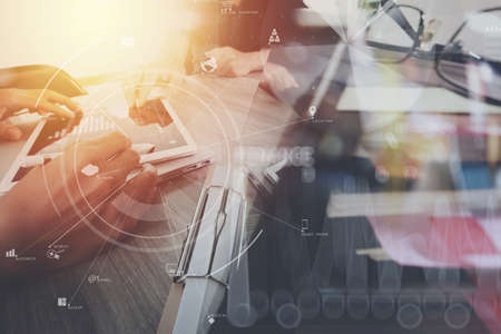 co working team meeting concept,businessman using mobile phone and digital tablet and laptop computer in modern office with virtual icon diagramの写真素材