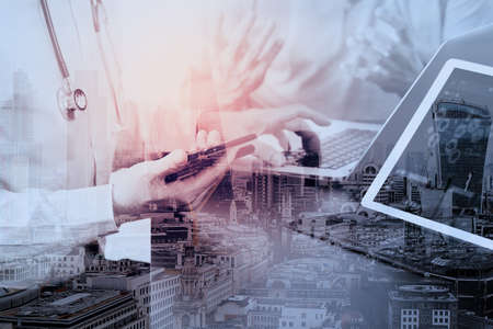 Medical co working concept,Doctor working with smart phone and digital tablet and laptop computer to meeting his team in modern office at hospital with London city exposureの写真素材