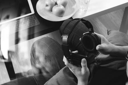 hipster hand holding headphone,using digital tablet docking keyboard and mobile payments online business,omni channel,sitting on sofa in living room,green apples in wooden tray,black and whiteの写真素材