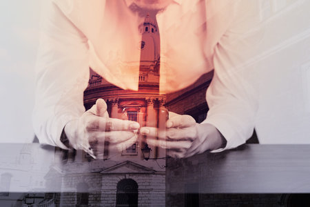 close up of businessman working with mobile  phone on wooden desk in modern office with virtual icon diagram with London city exposureの写真素材